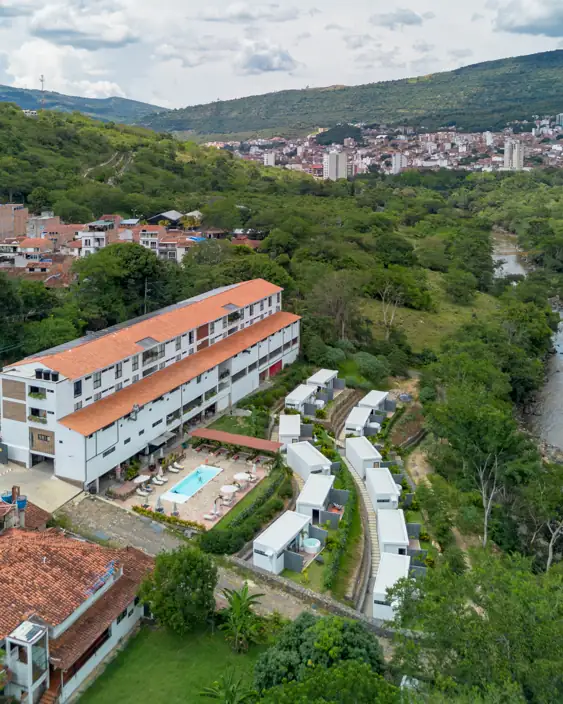 Las cabañas, el hotel y la piscina con el valle del Fonce y San Gil detrás